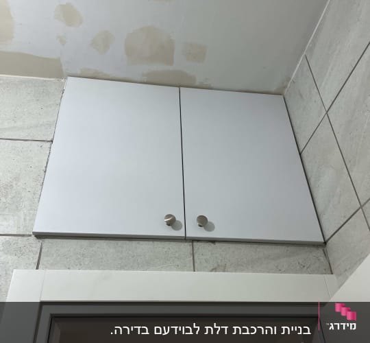 ארון קיר עם דלתות לבנות וידיות עגולות